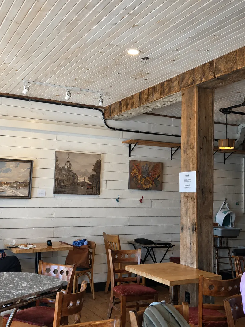 Wooden beams, white walls and tables inside Cottage Cafe.