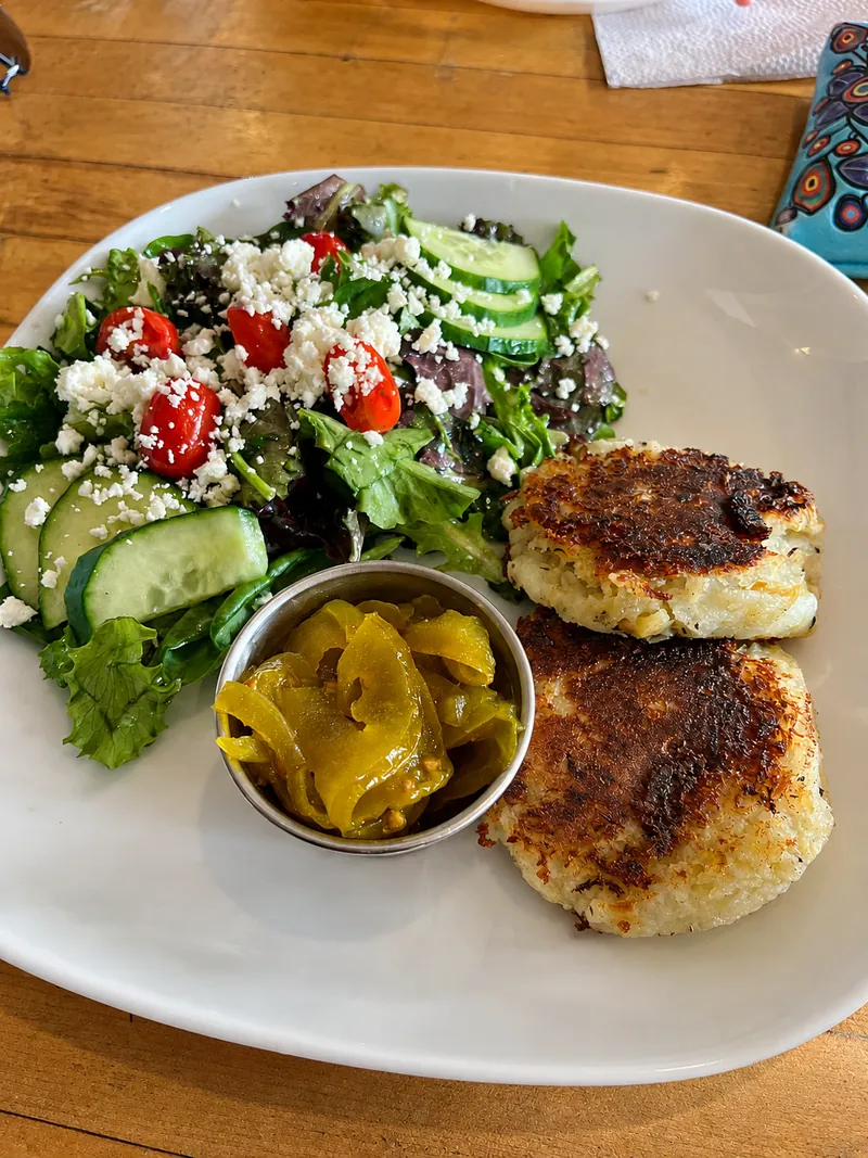 Two fish cakes with salad and a small dish of relish.