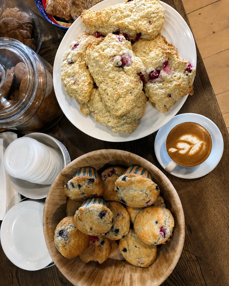 Scones, muffins and a cup of coffee on the cafe counter.